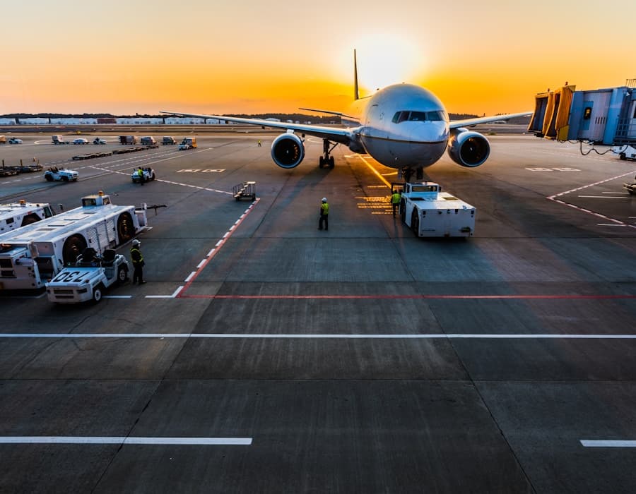 Aircraft parked at an airport gate at sunset