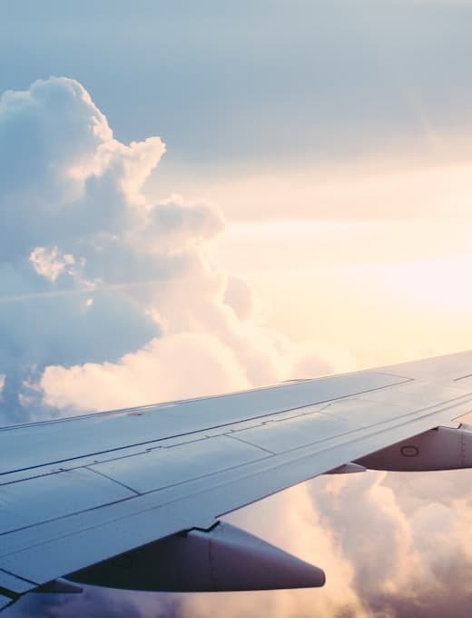 View of clouds from an aircraft window at sunset